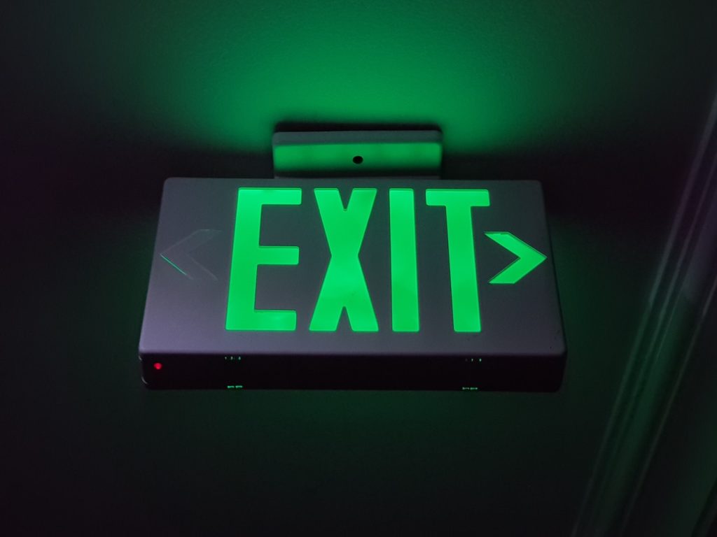 A green EXIT sign on a ceiling