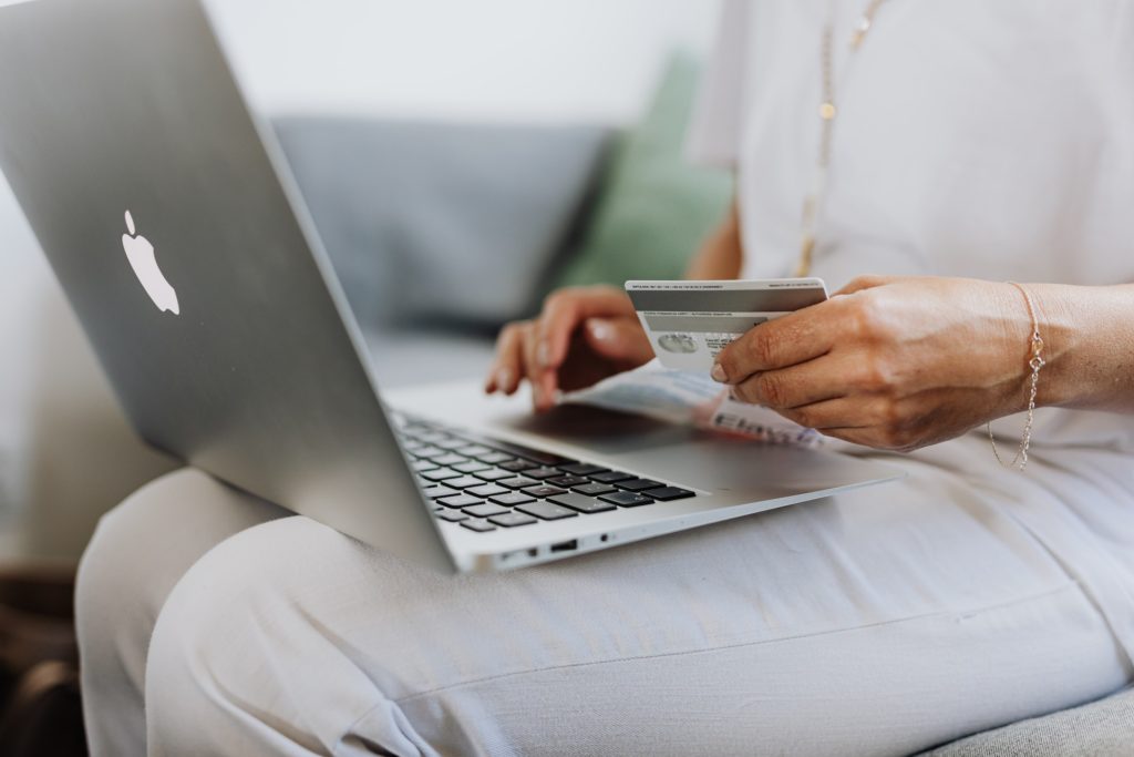 A photo of a woman paying on her laptop with a credit card
