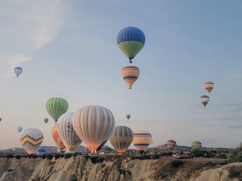 Hot air balloons lifting off in a crowd on vacation